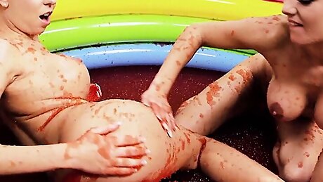 Barbie looking blonde lesbians with big fake tits rubbing each other in a pool full of jelly