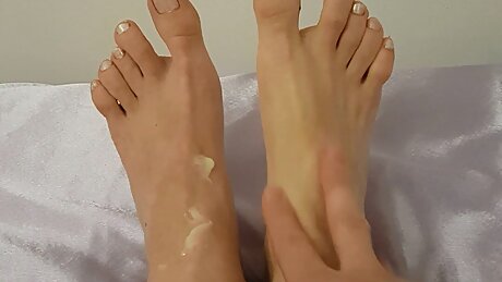 White nail varnish and massage with foot cream