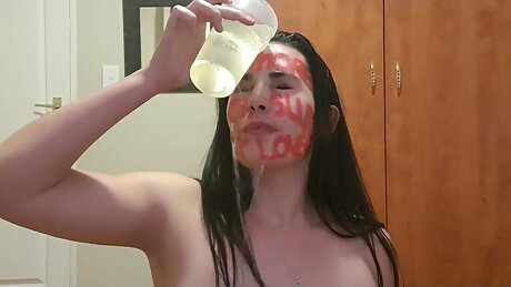Slut full of degrading lipstick writing on her face humiliating herself as she talks dirty to the viewer