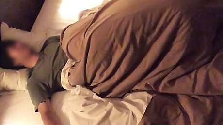 She crawls under the covers and sucks out her boyfriend's cock.